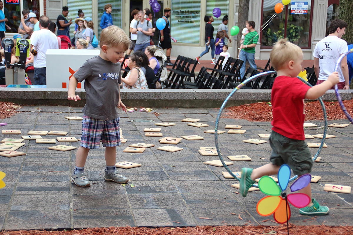 Young boys playing with hula hoops in street