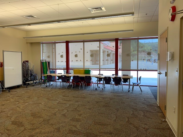 Meeting Room B with tables, chairs, and large windows