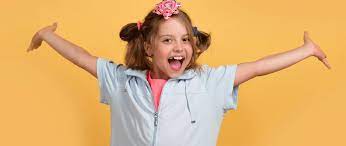Happy girl with arms outstretched against yellow background