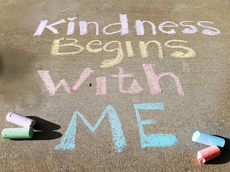 Sidewalk chalk message "Kindness Begins with Me"
