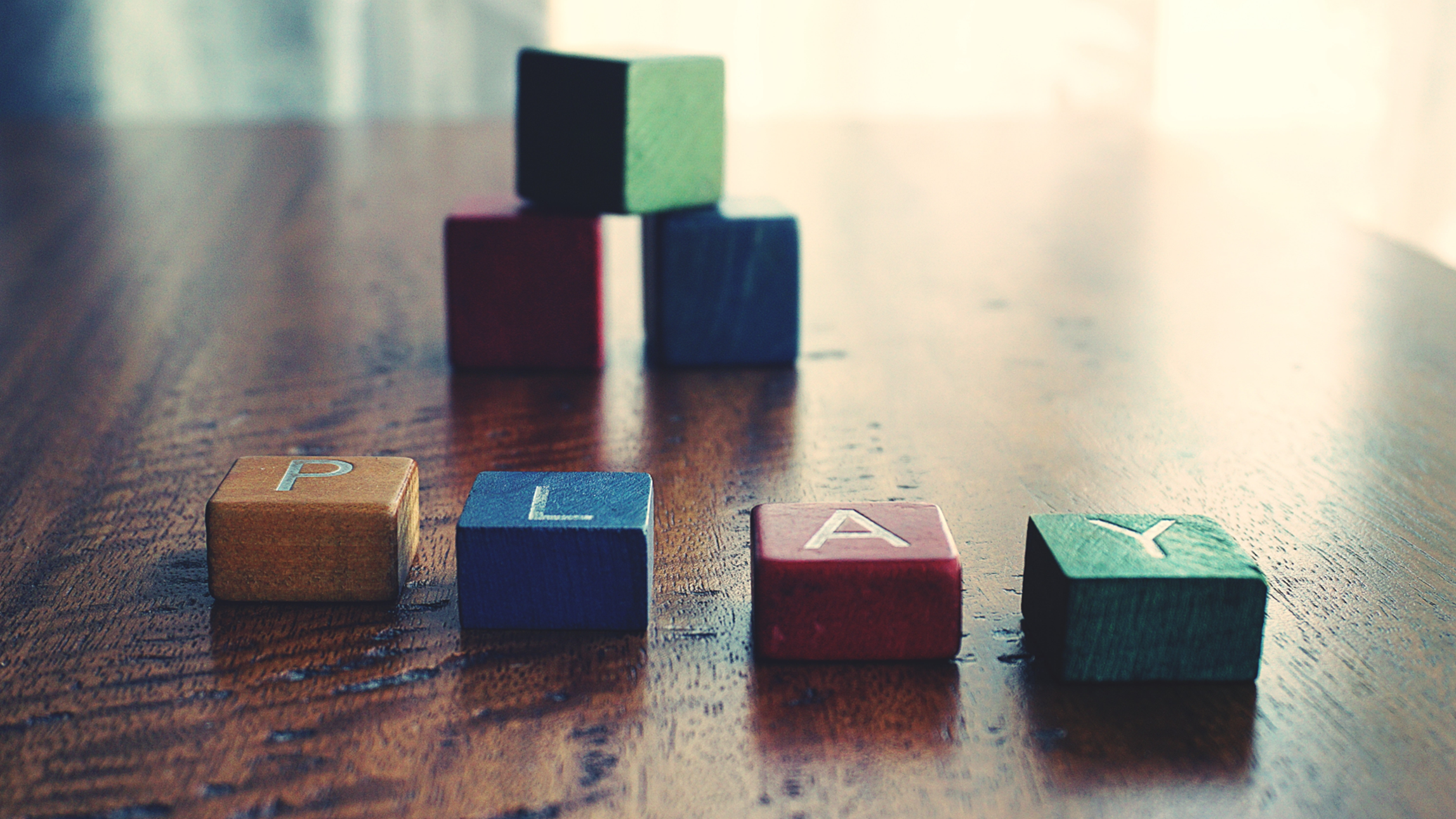 colorful wooden blocks spell out PLAY