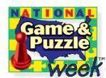 Blue, green, yellow background with red game piece with words "National Game and Puzzle Week"