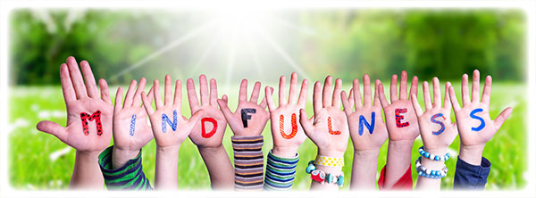 Variety of children's hands with the word MINDFULNESS on them