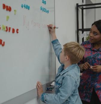 Teacher helping student at markerboard