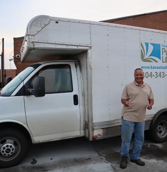 Gary Turpin stands in front of the white KCPL courier truck at Dunbar Branch, giving the thumbs up