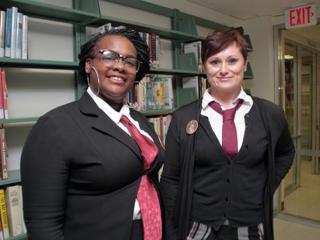 Two women dressed in Hogwarts jackets with red ties
