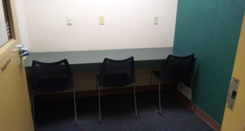 Study room with thee chairs and a table against the wall