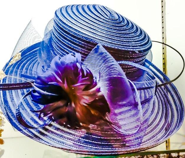 Blue hat with wide brim, multicolored feathers and bow