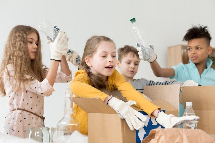 Four children working together to sort items in boxes