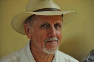 Bearded man in a white shirt wearing a hat