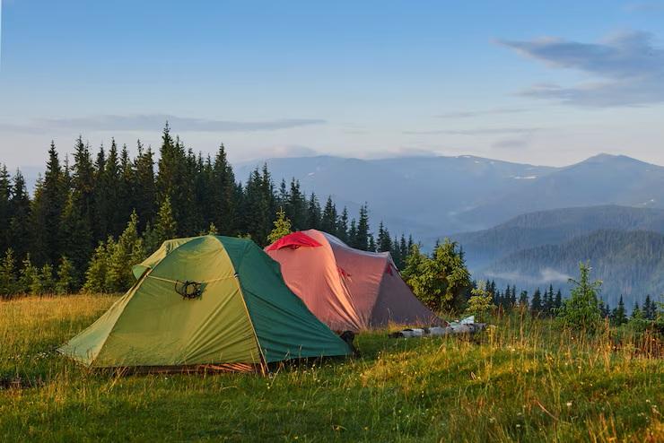 Green & Red Tents with blue mountains in background