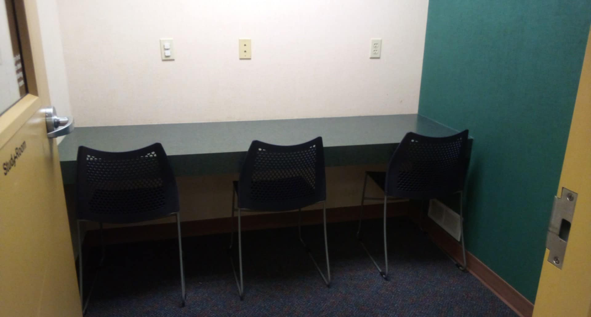 Study room with thee chairs and a table against the wall